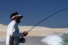 Fly fishing at sunrise from the beach in Cabo with view of calm Sea of Cortez waters