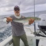 Angler holding a fresh-caught Sierra mackerel during an inshore fishing trip in San José del Cabo.