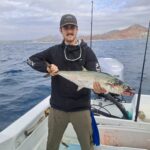Fishing guide displays a vibrant Spanish mackerel caught near the shore in Los Cabos.