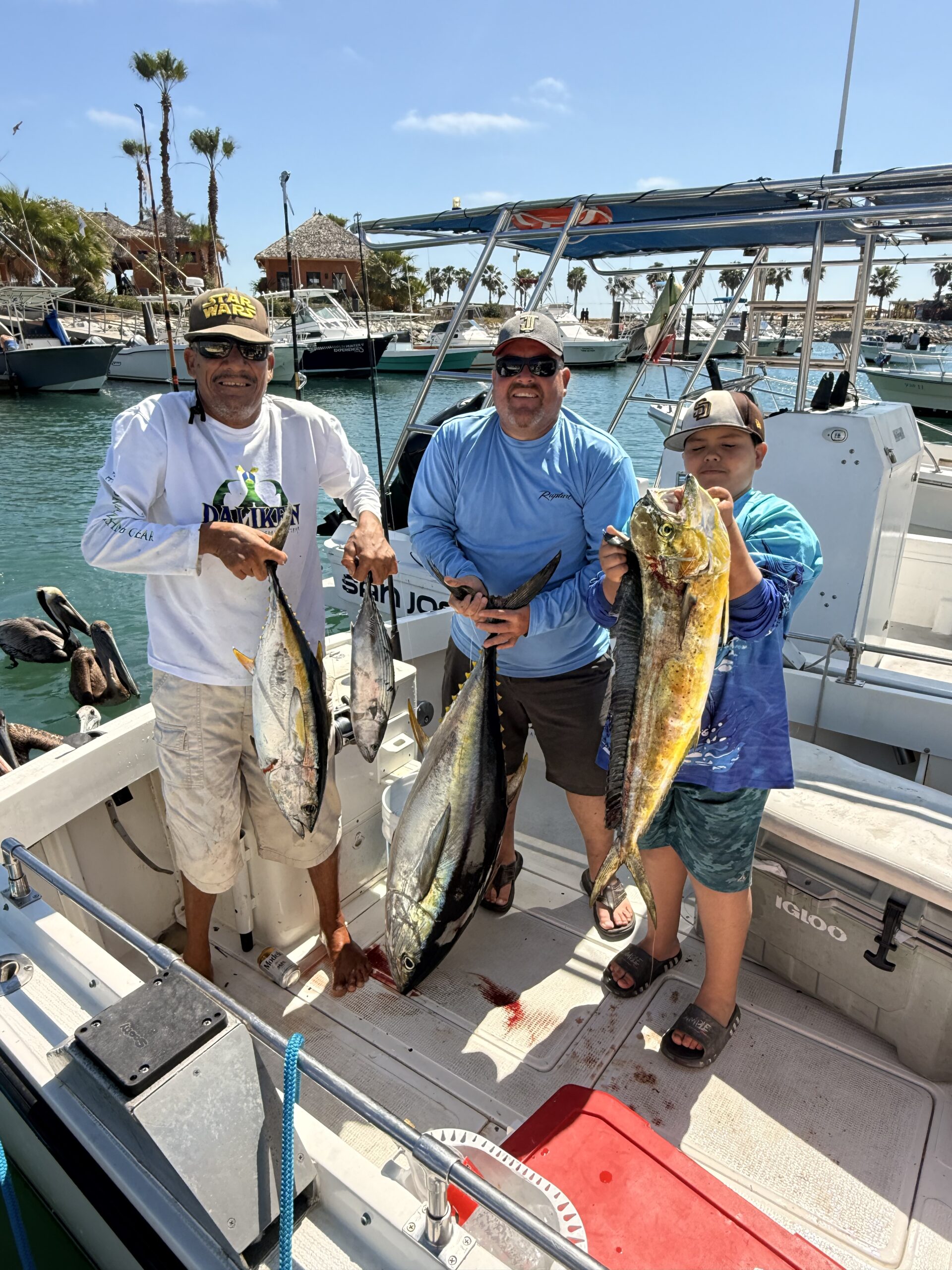 Happy sportfishing clients in San Jose del Cabo holding fresh tuna after a successful offshore charter
