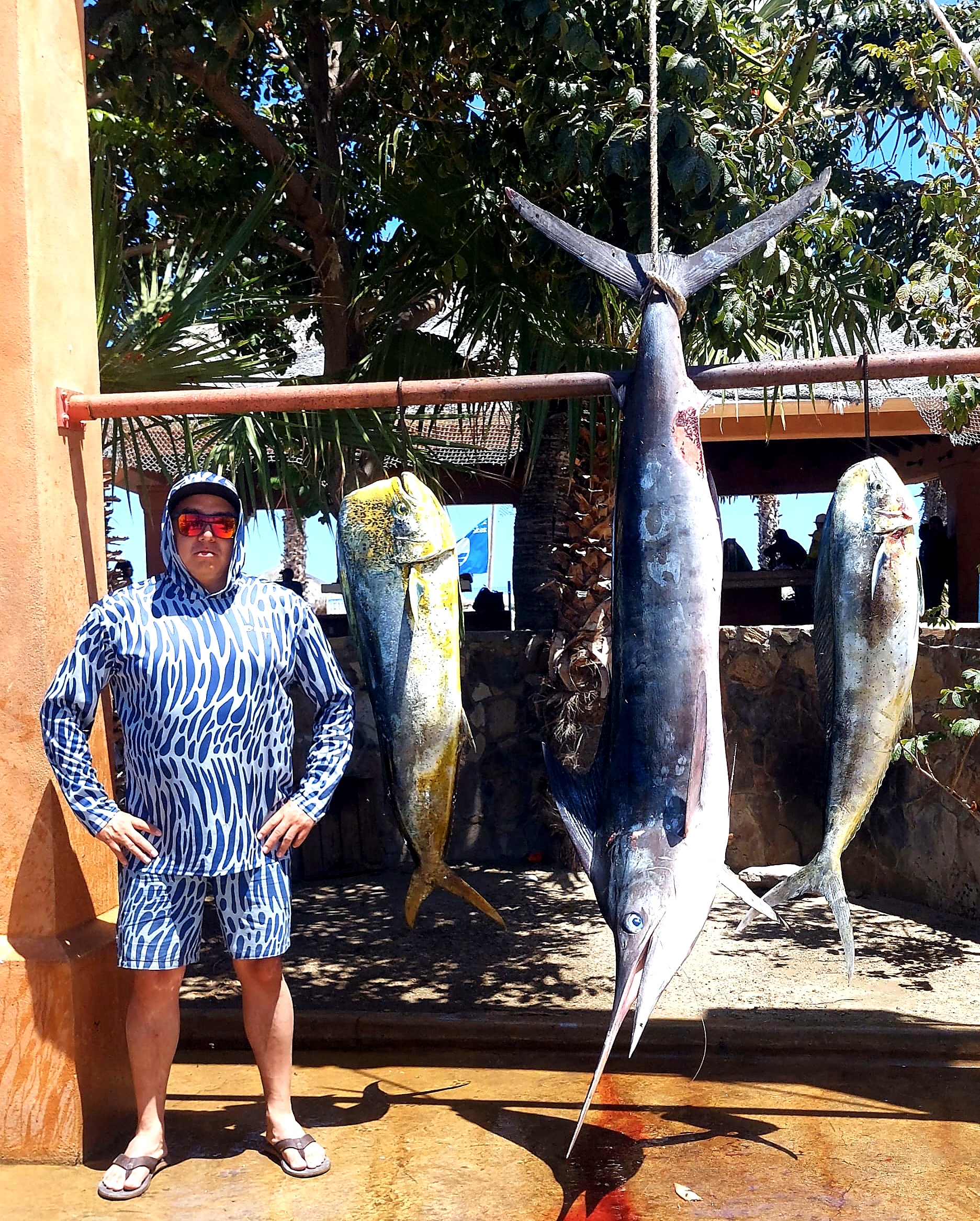 Happy clients holding fresh catch after a productive private fishing charter in San José del Cabo