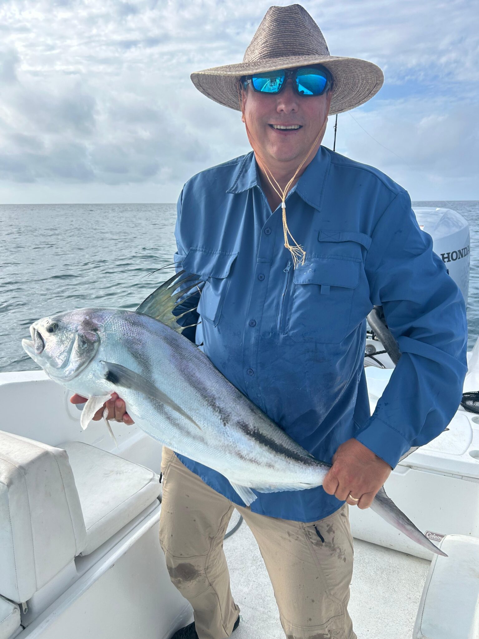 Guest holding a striped roosterfish aboard the 33ft ABAMAR charter in San Jose del Cabo