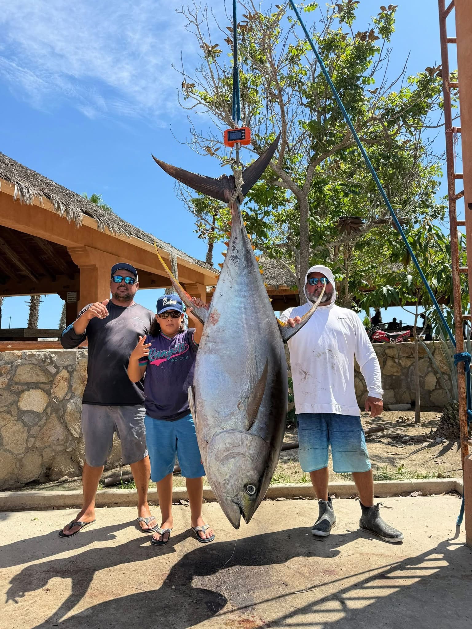 Family weighing a large tuna caught on a Daliken Sportfishing charter in Los Cabos